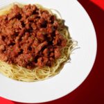 Top-down view of plant-based spaghetti Bolognese with vegan meat sauce on a white plate – Amoria Foods