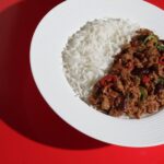 Plant-based chilli con carne with rice on bold red background – Amoria Foods